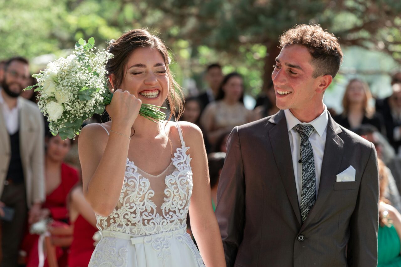 A happy bride and groom walk down the aisle outdoors, surrounded by nature and guests, in Uspallata, Argentina.